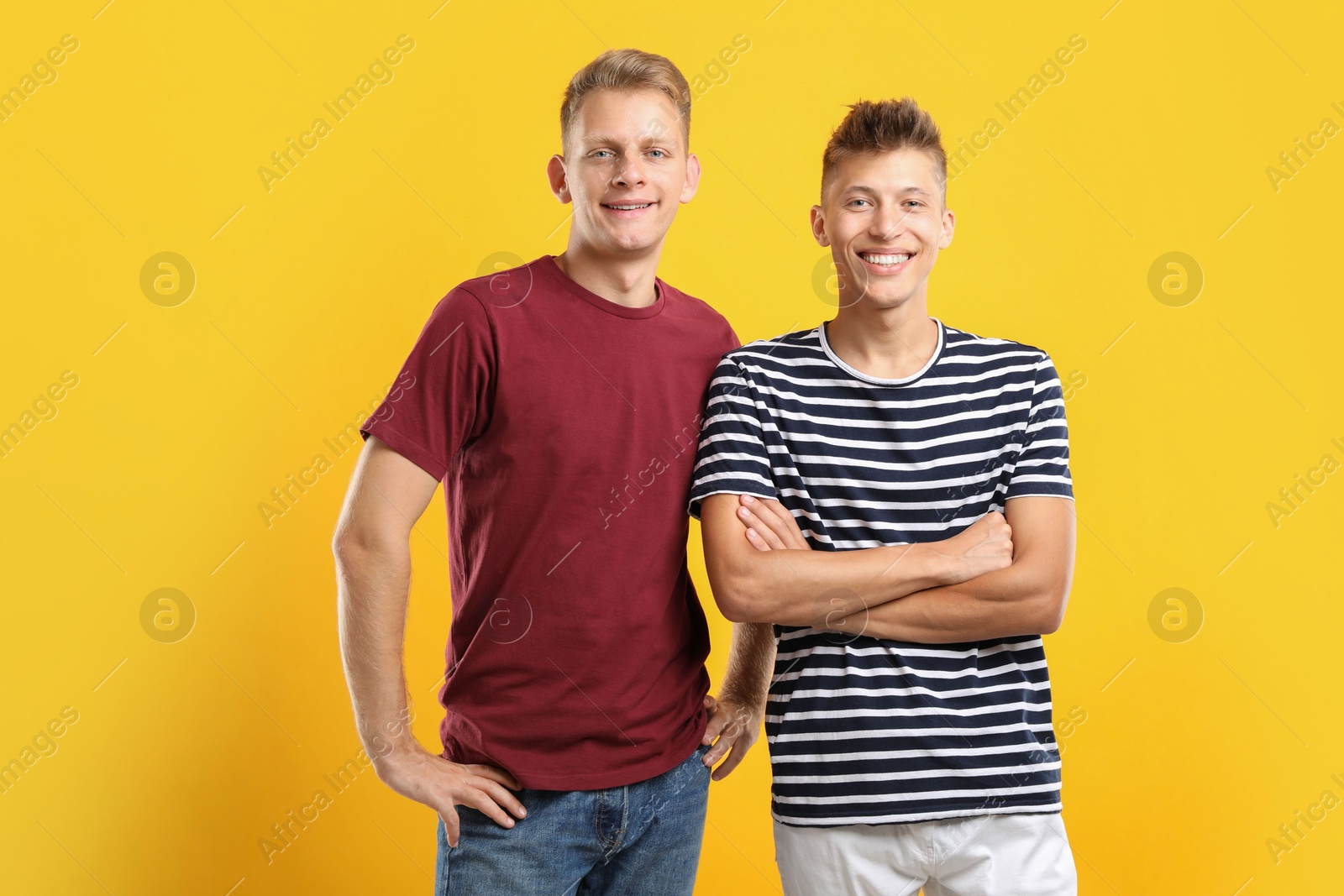 Photo of Portrait of happy brothers on orange background