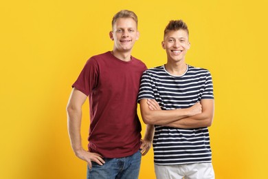 Portrait of happy brothers on orange background