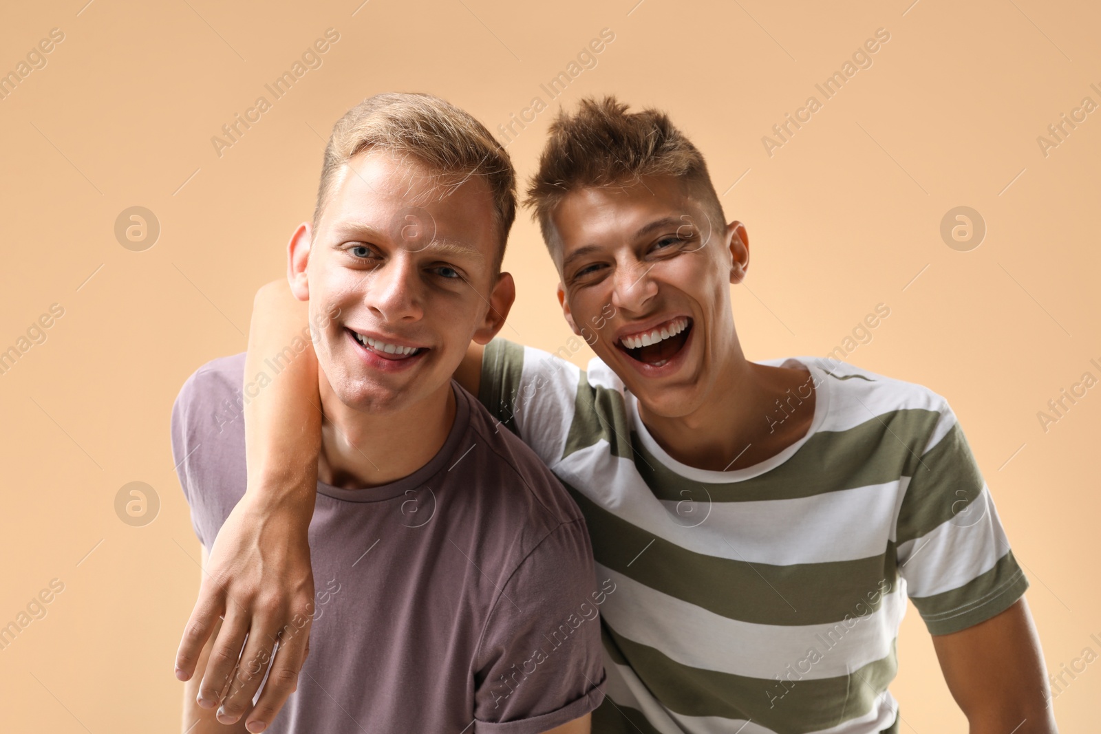 Photo of Portrait of happy brothers on beige background