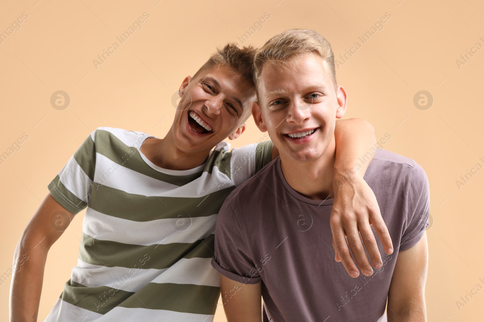 Photo of Portrait of happy brothers on beige background