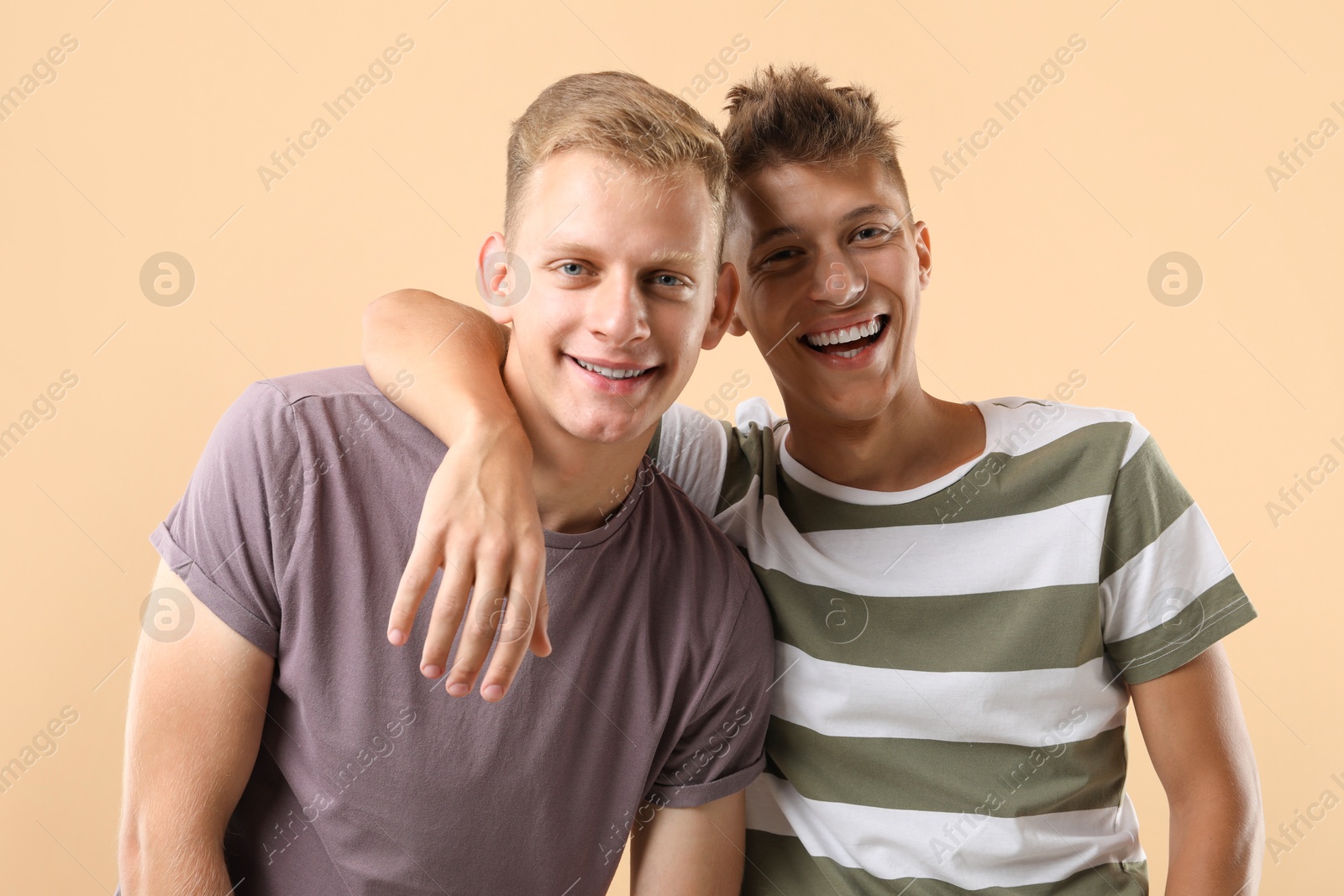 Photo of Portrait of happy brothers on beige background