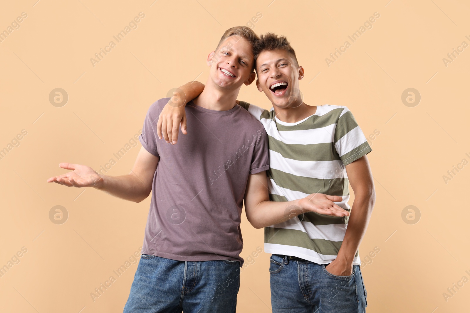 Photo of Portrait of happy brothers on beige background