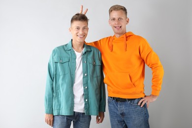 Portrait of two funny brothers on light background