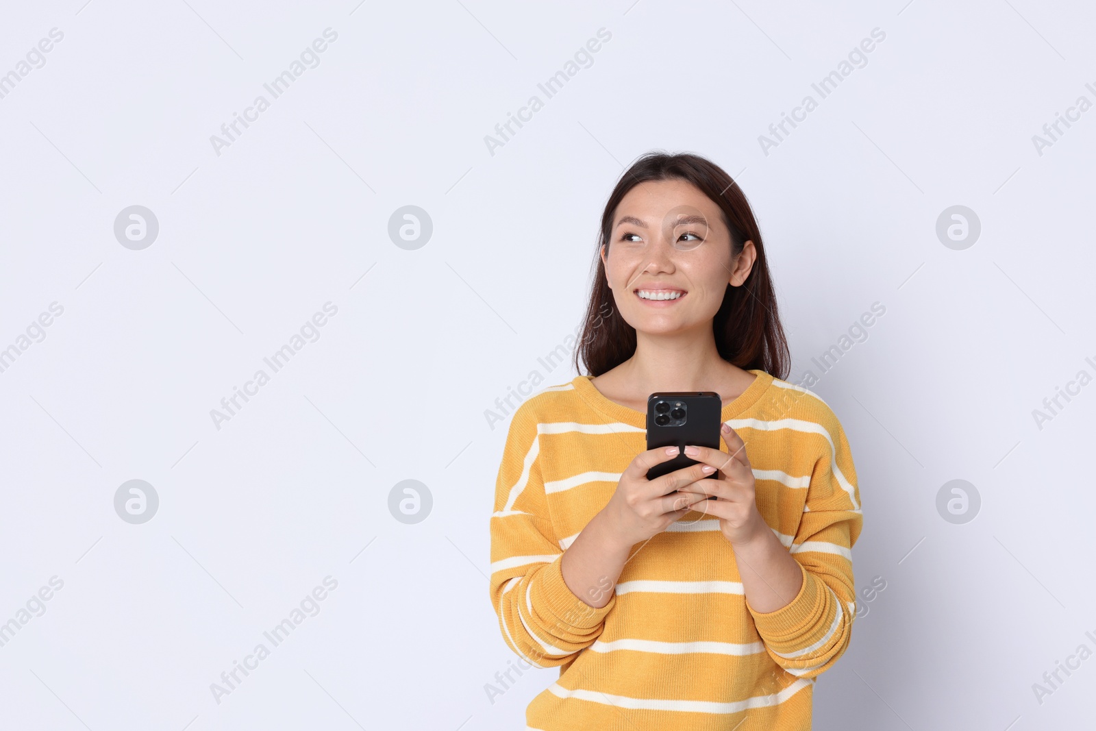 Photo of Smiling woman with smartphone on white background. Space for text