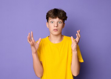 Photo of Portrait of scared teenage boy on violet background