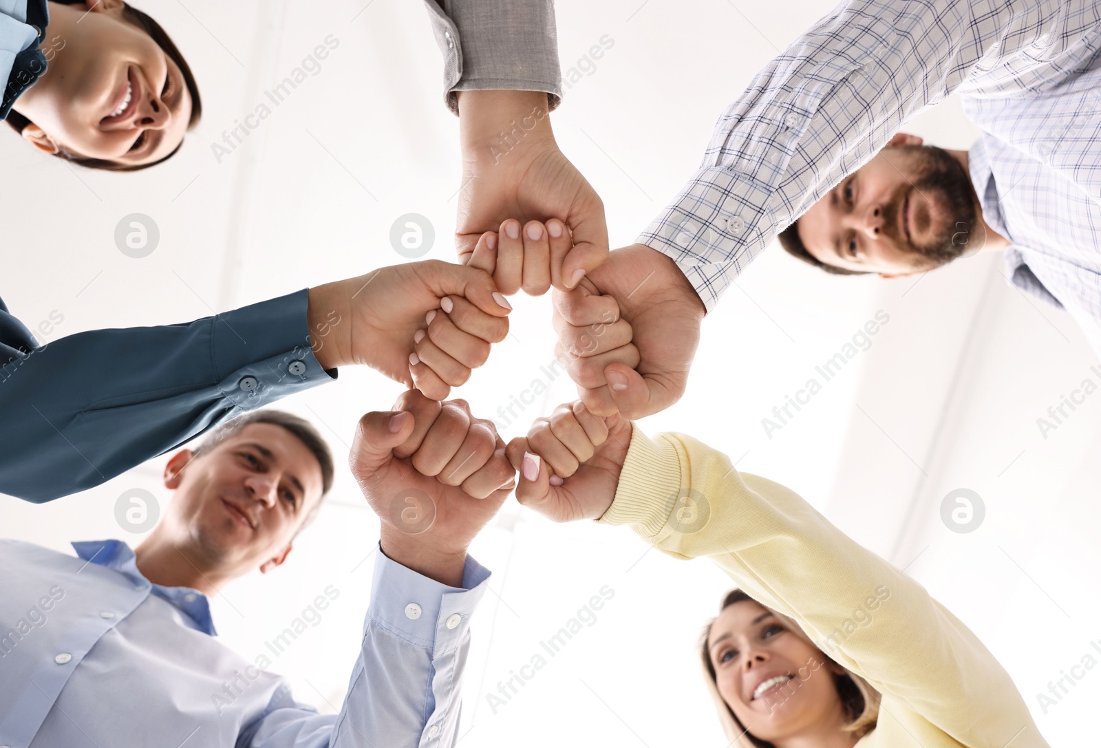 Photo of Teamwork. Group of employees joining hands in office, bottom view