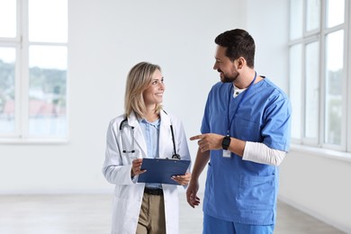 Photo of Healthcare workers with clipboard talking in hospital