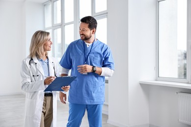 Healthcare workers with clipboard talking in hospital