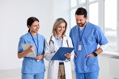 Group of healthcare workers with clipboard and tablet in hospital