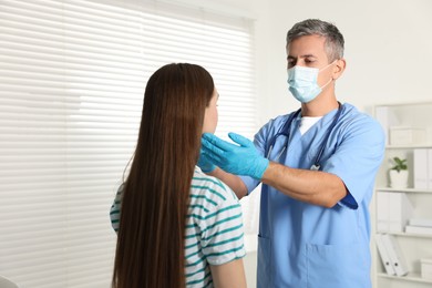 Doctor examining woman's throat in clinic during appointment