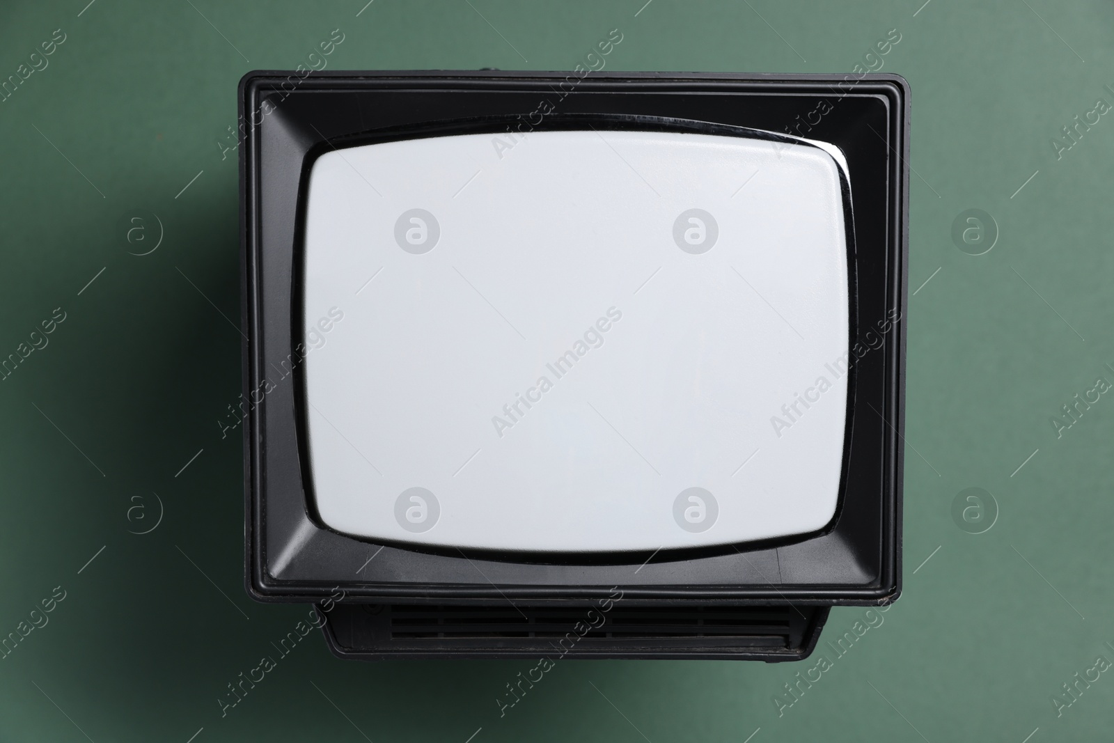 Photo of Retro tv set on green background, top view