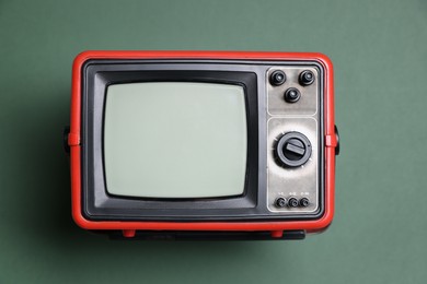 Photo of Retro tv set on green background, top view