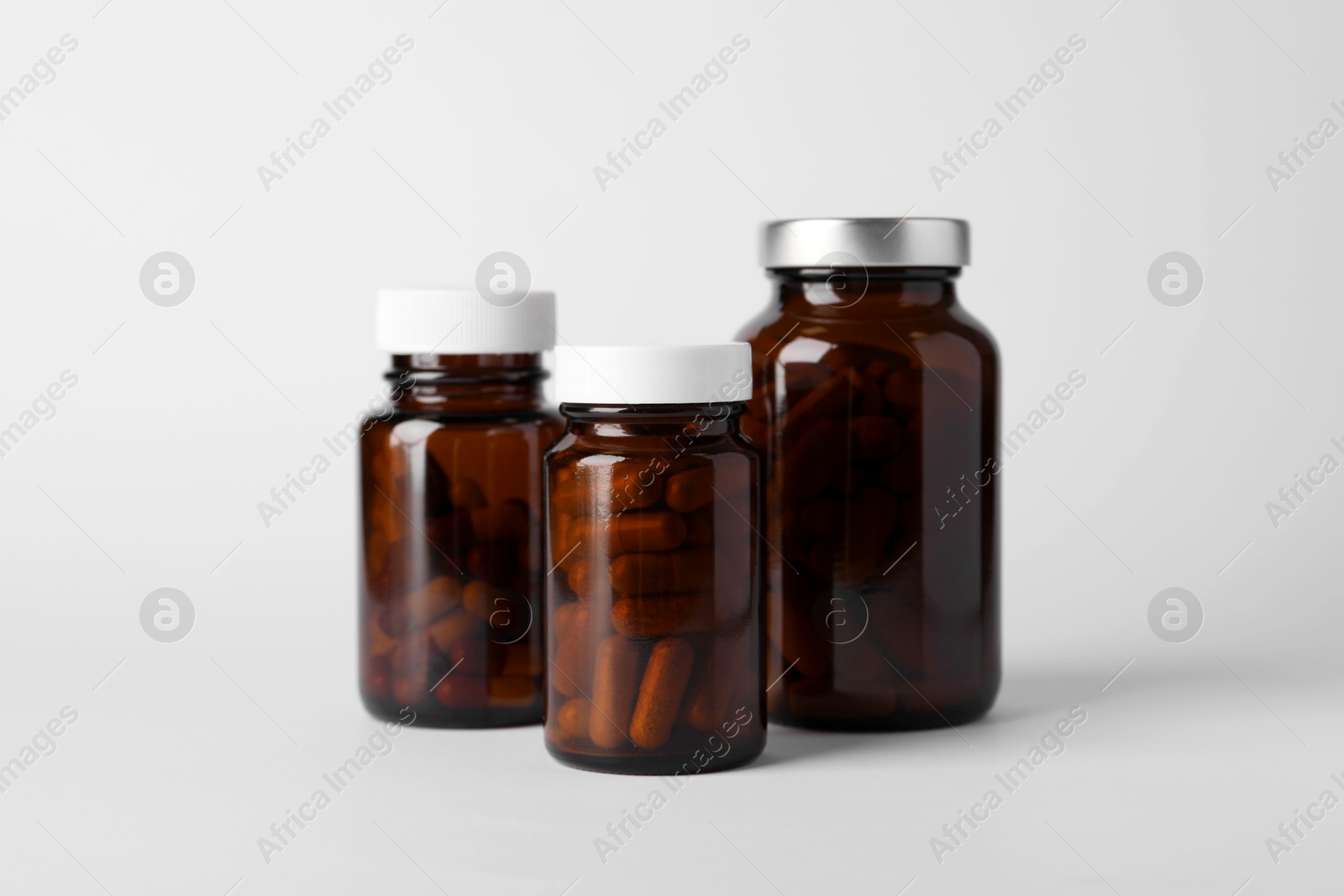 Photo of Medical bottles with pills on white background