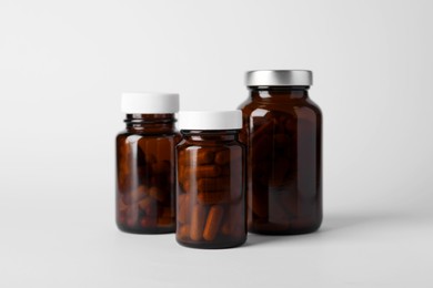 Photo of Medical bottles with pills on white background