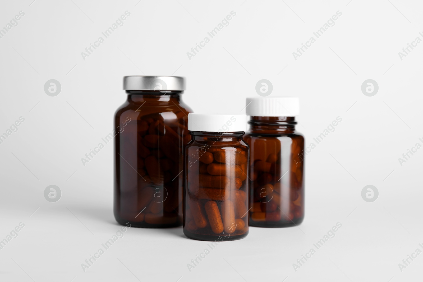 Photo of Medical bottles with pills on white background