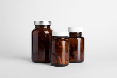 Photo of Medical bottles with pills on white background