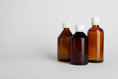 Photo of Medical bottles with medicine on white background, space for text