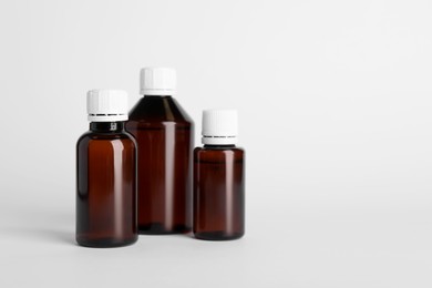 Photo of Medical bottles with medicine on white background, space for text