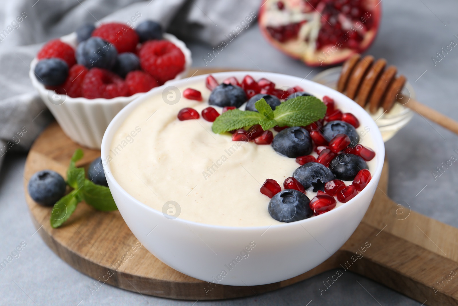 Photo of Tasty cooked semolina porridge served on grey table, closeup