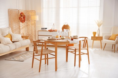 Photo of Stylish table setting with beautiful dishware and autumn decor in dining room