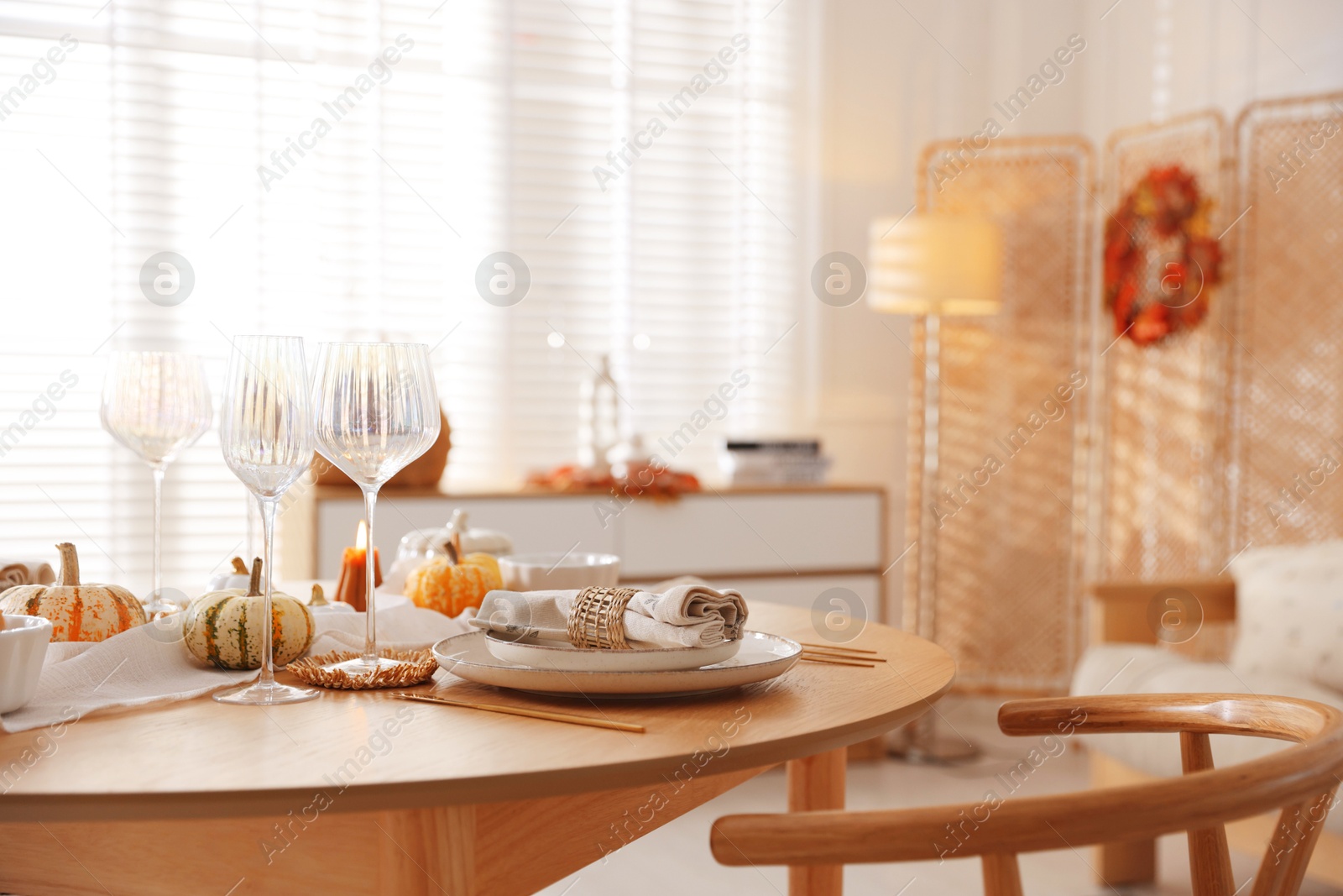 Photo of Stylish table setting with beautiful dishware and autumn decor in dining room