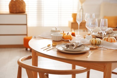 Photo of Stylish table setting with beautiful dishware and autumn decor in dining room