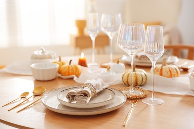 Photo of Stylish table setting with beautiful dishware and autumn decor in dining room