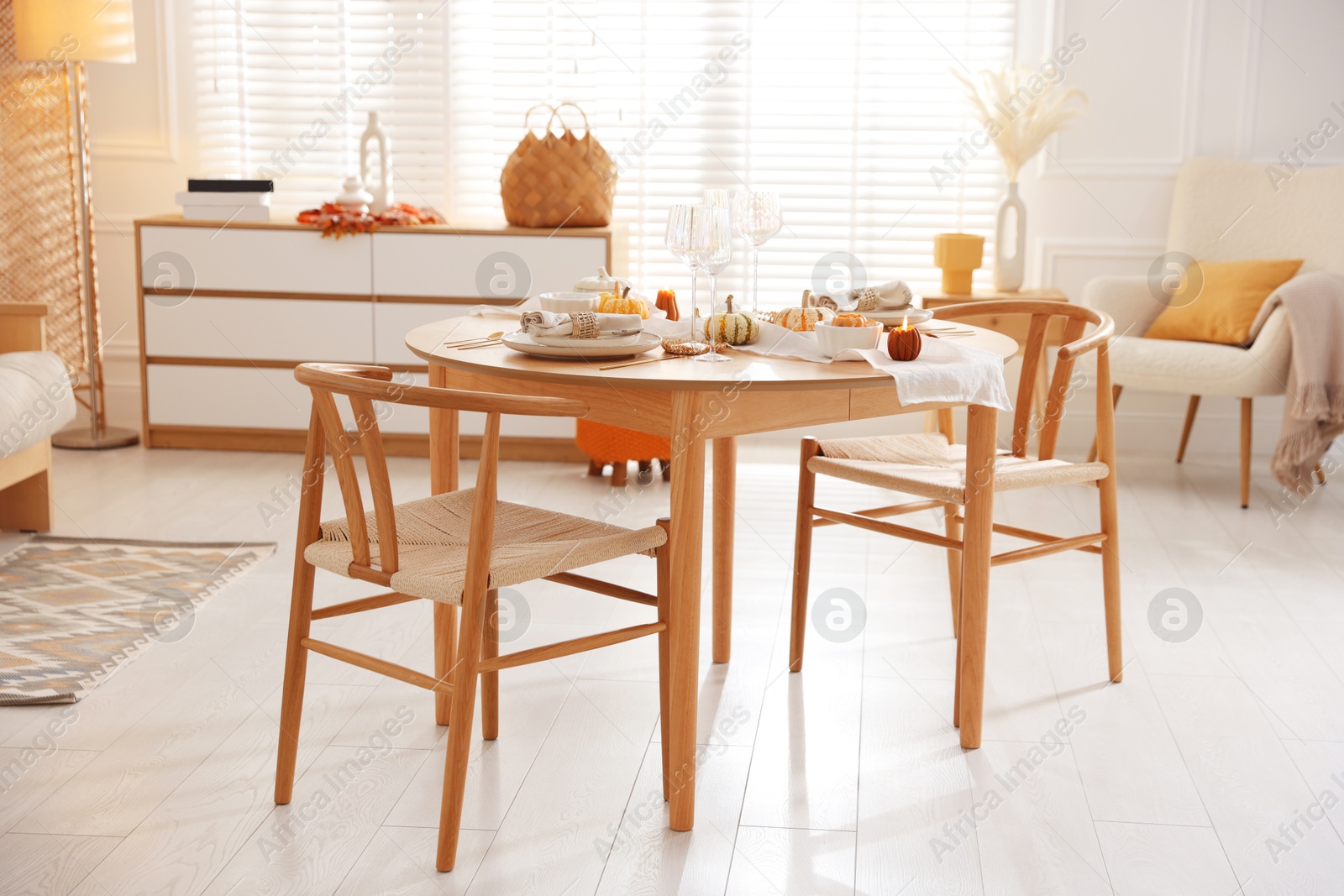 Photo of Stylish table setting with beautiful dishware and autumn decor in dining room