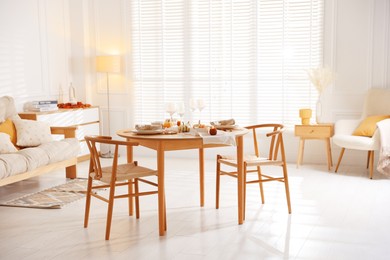 Stylish table setting with beautiful dishware and autumn decor in dining room