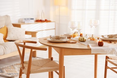 Photo of Stylish table setting with beautiful dishware and autumn decor in dining room