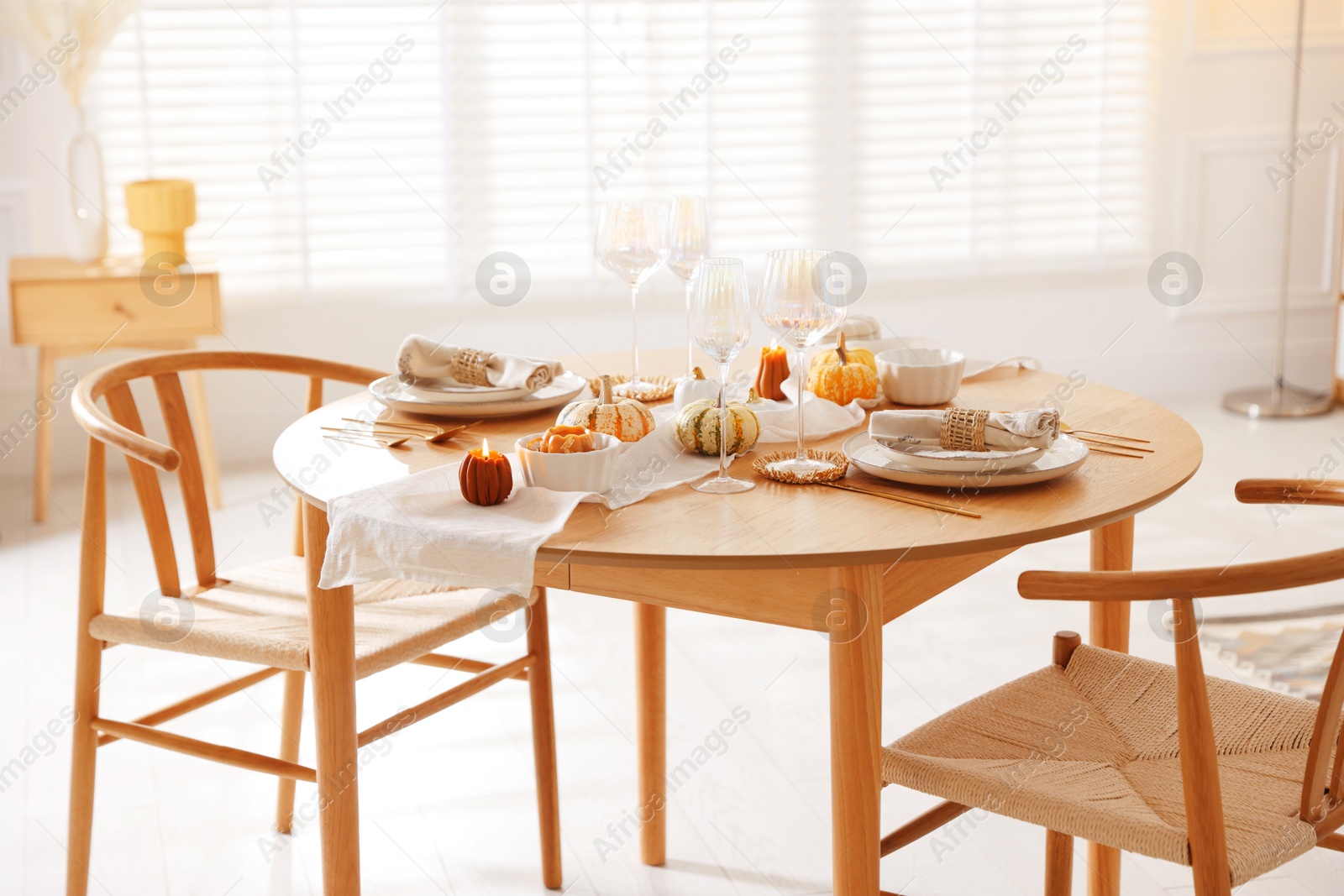 Photo of Stylish table setting with beautiful dishware and autumn decor in dining room