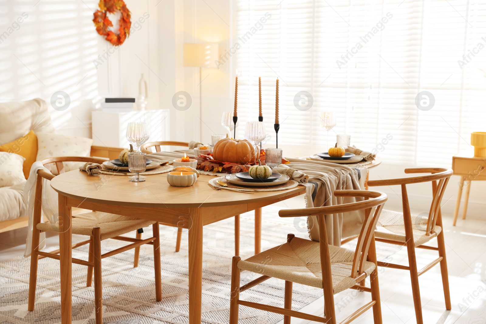 Photo of Stylish table setting with beautiful dishware and autumn decor in dining room