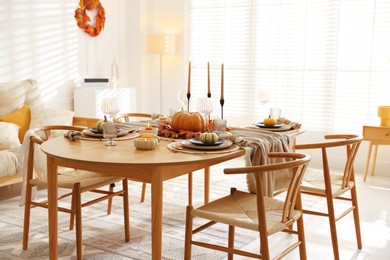 Photo of Stylish table setting with beautiful dishware and autumn decor in dining room