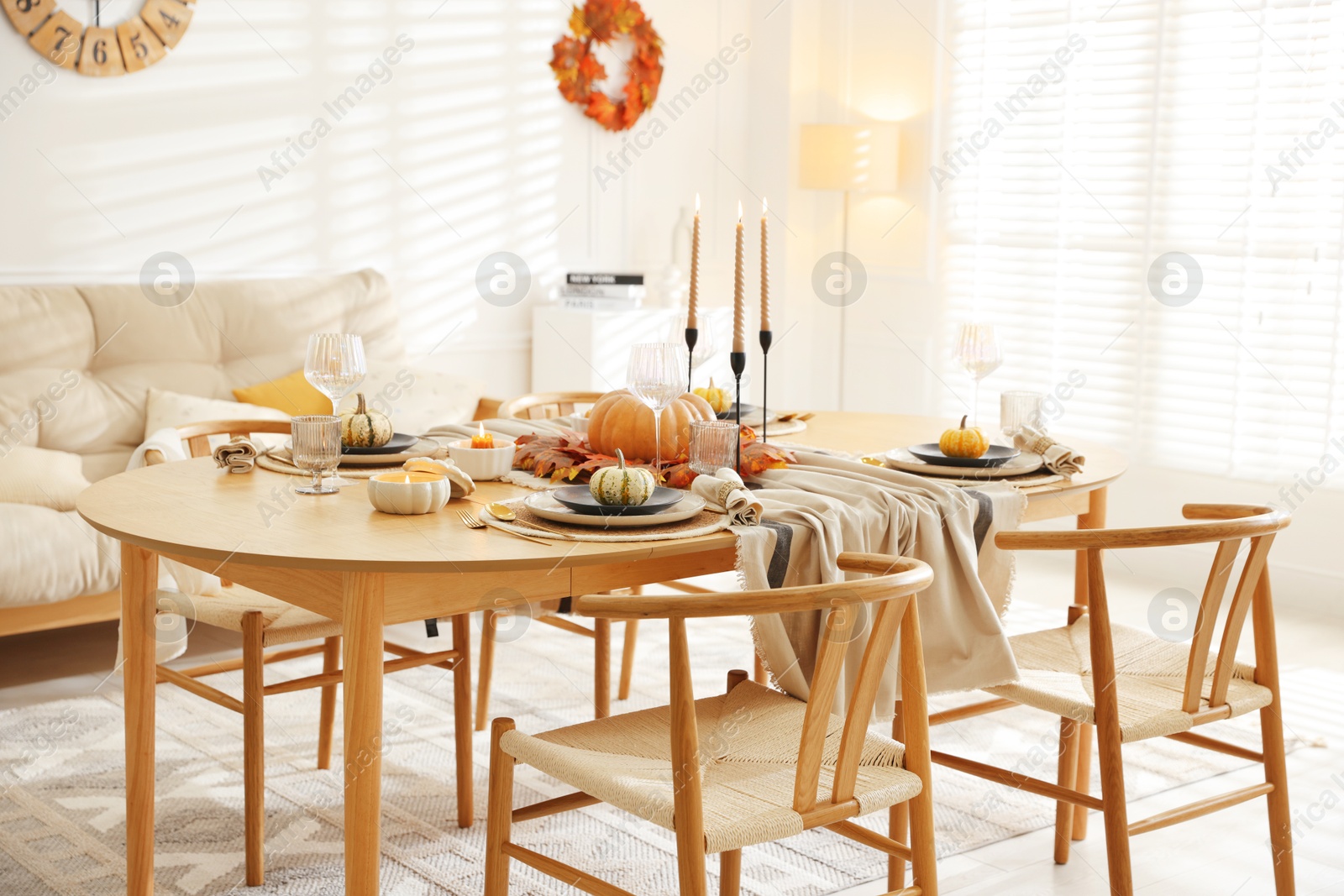 Photo of Stylish table setting with beautiful dishware and autumn decor in dining room