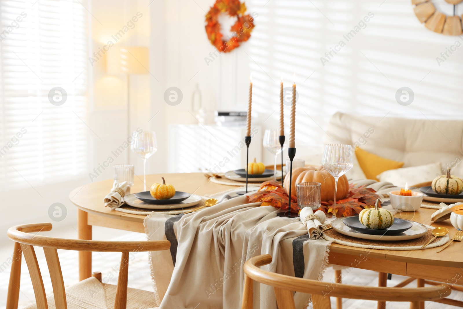 Photo of Stylish table setting with beautiful dishware and autumn decor in dining room