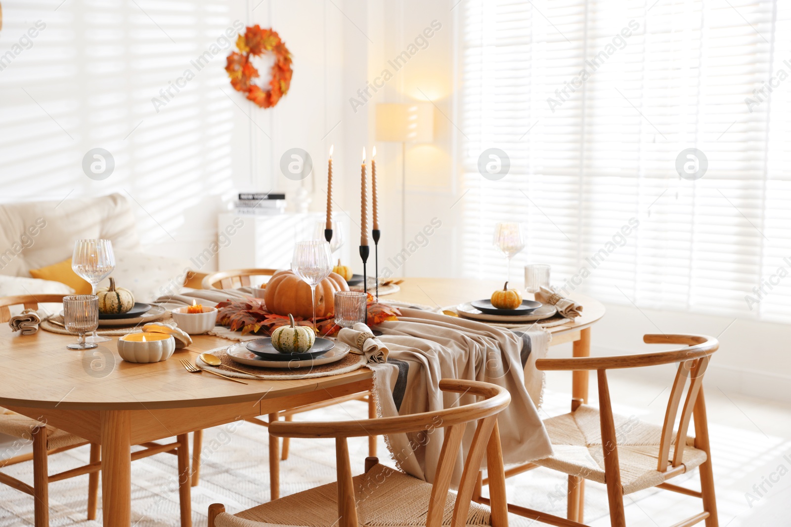 Photo of Stylish table setting with beautiful dishware and autumn decor in dining room