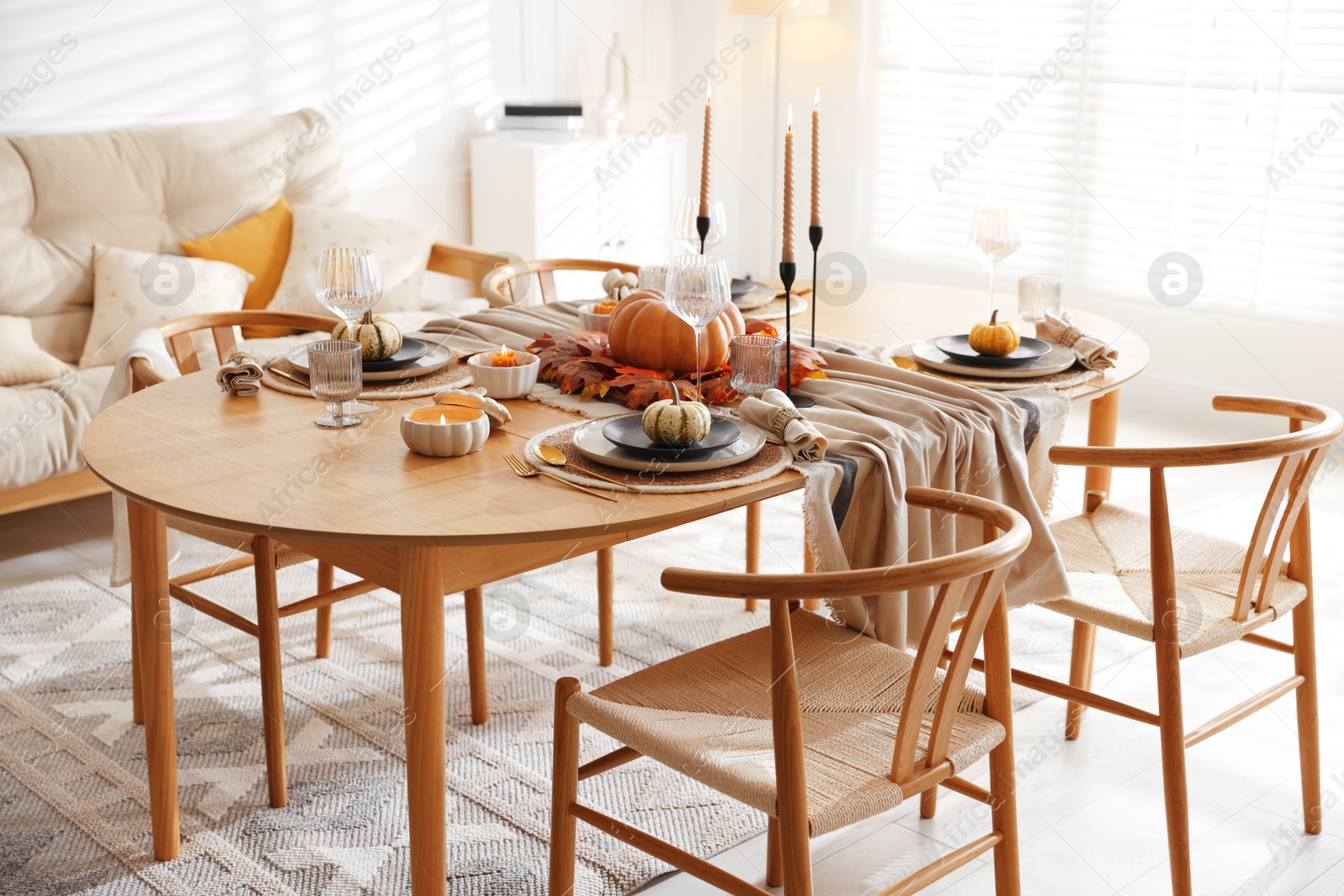 Photo of Stylish table setting with beautiful dishware and autumn decor in dining room