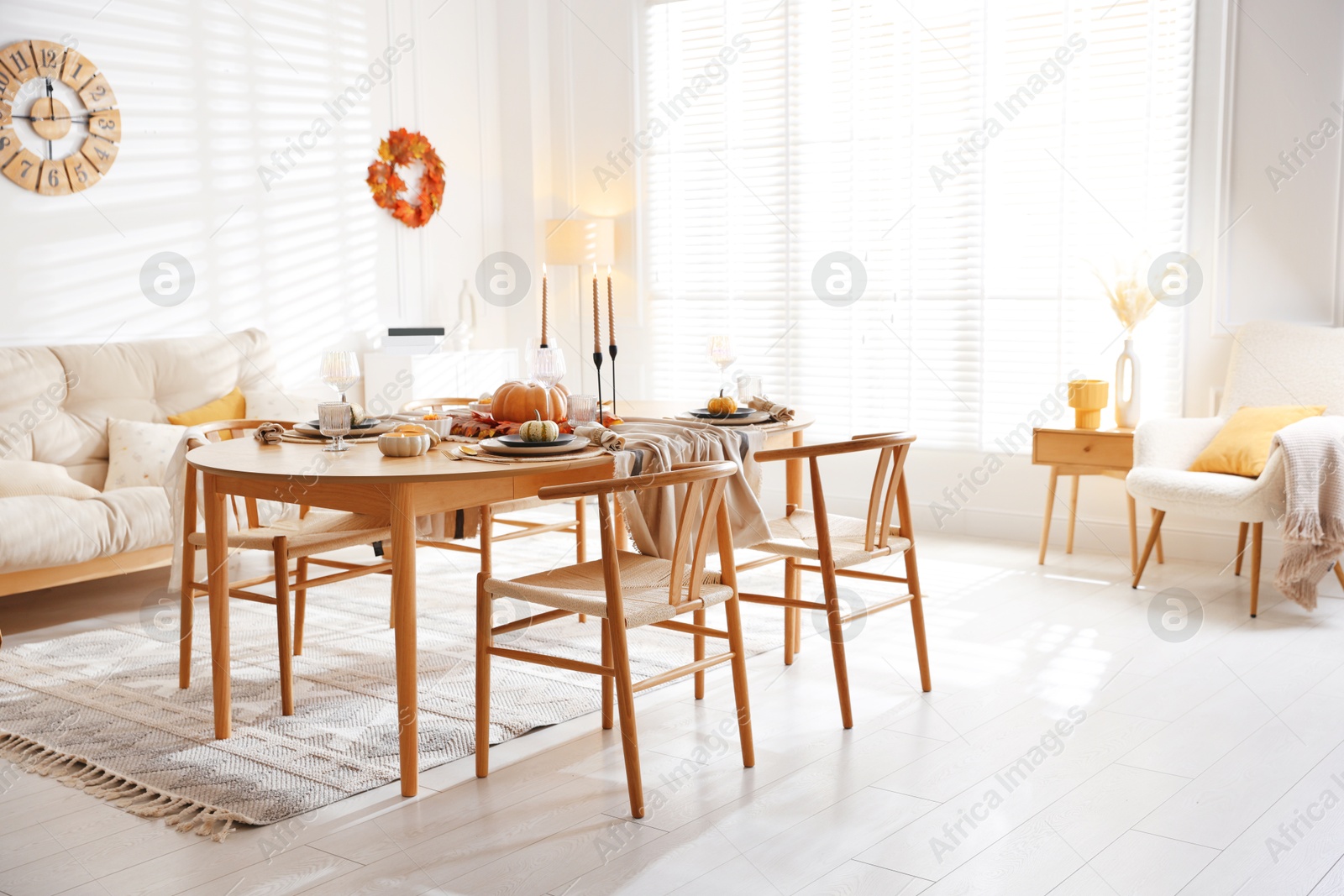 Photo of Stylish table setting with beautiful dishware and autumn decor in dining room