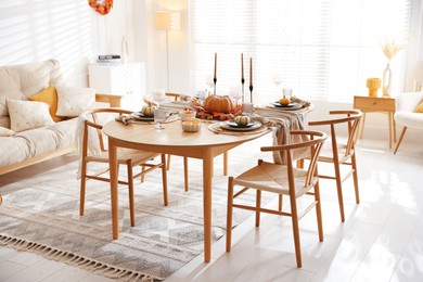 Photo of Stylish table setting with beautiful dishware and autumn decor in dining room