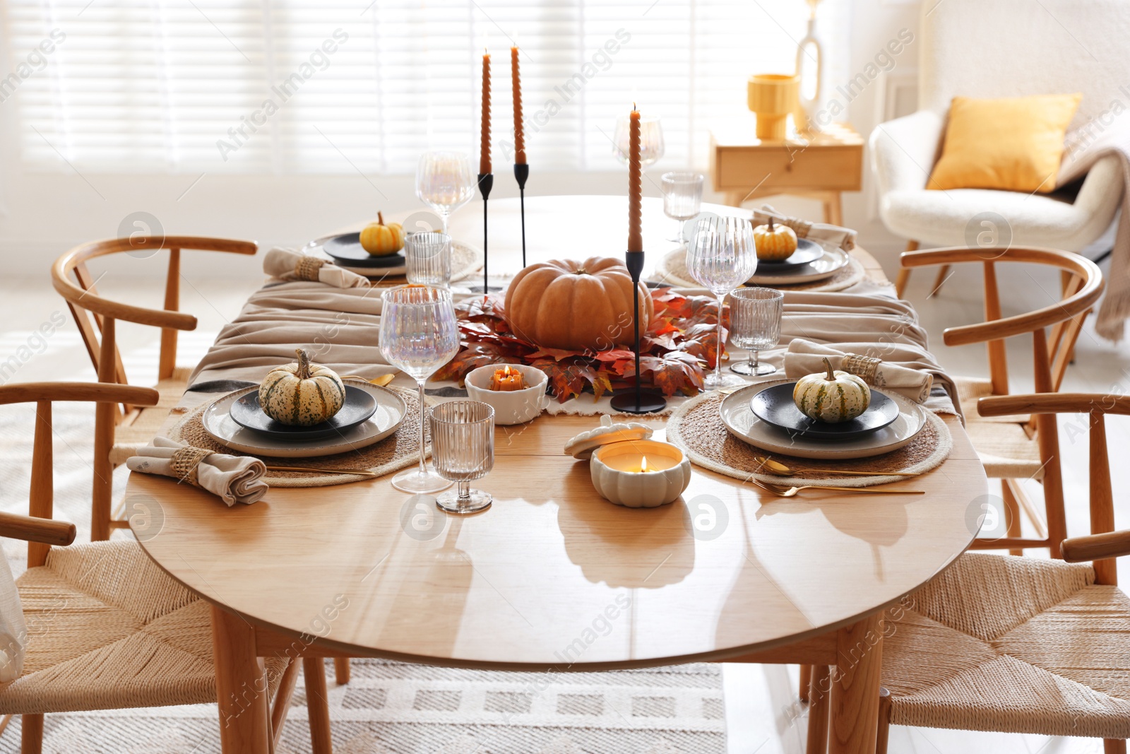 Photo of Stylish table setting with beautiful dishware and autumn decor in dining room