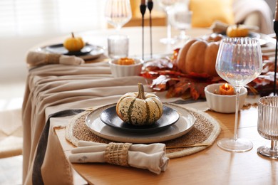 Photo of Stylish table setting with beautiful dishware and autumn decor in dining room