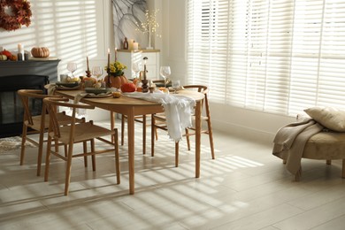 Photo of Stylish dining room with beautiful table setting and autumn decor