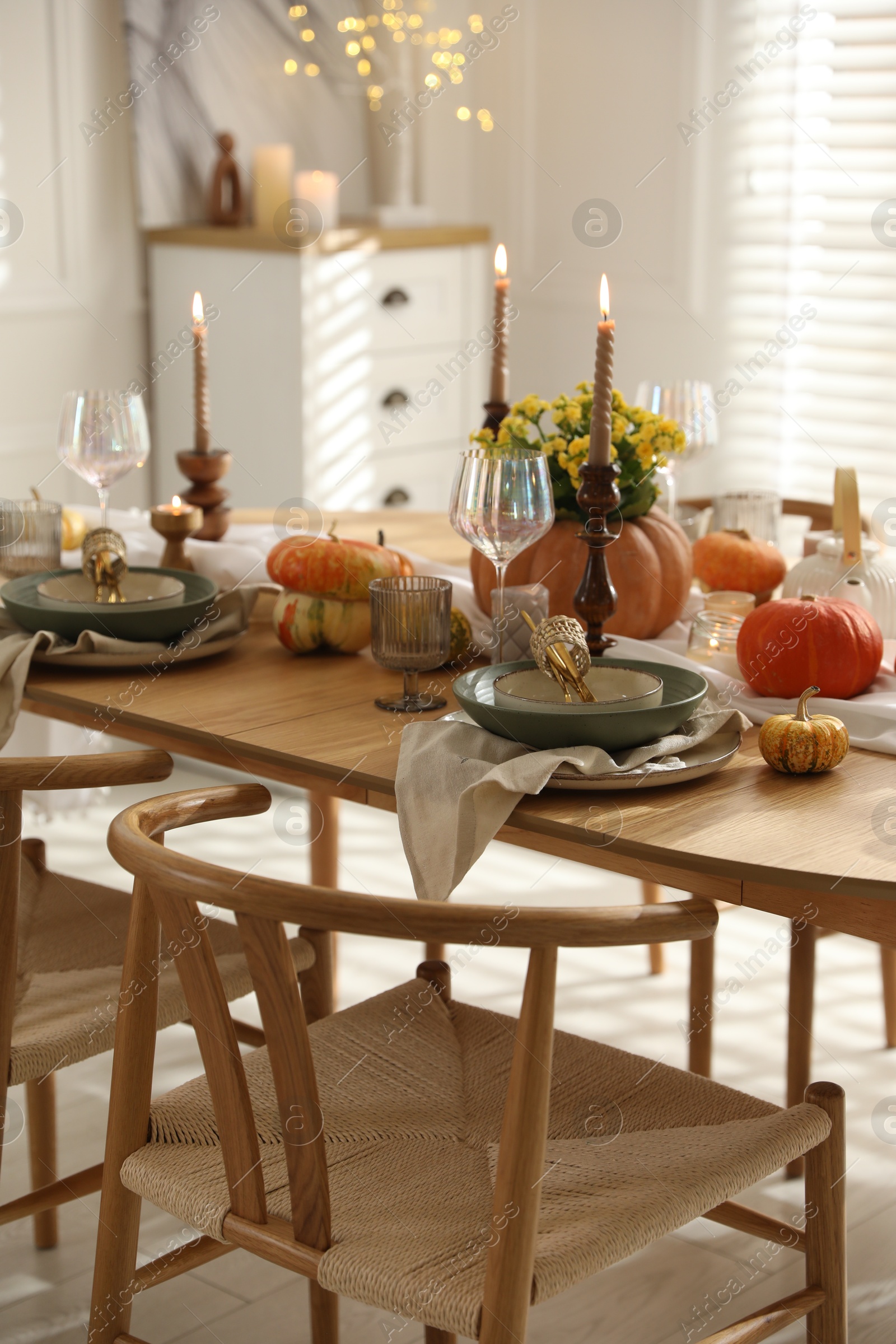 Photo of Stylish table setting with beautiful dishware, glasses and autumn decor in dining room