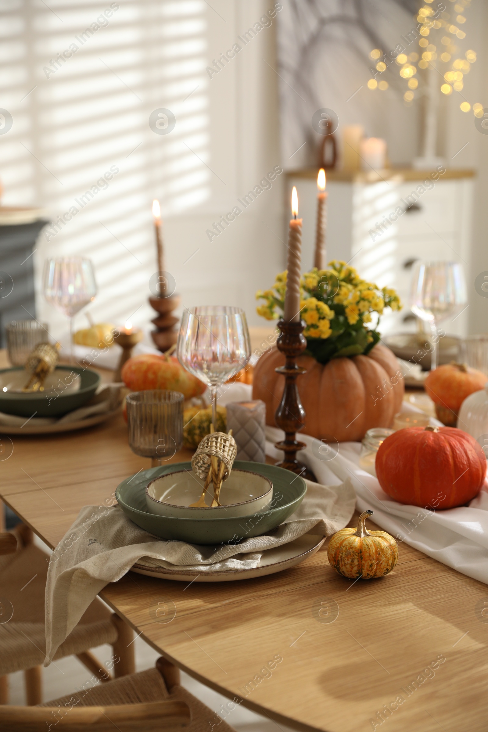 Photo of Stylish table setting with beautiful dishware, glasses and autumn decor in dining room