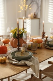 Photo of Stylish table setting with beautiful dishware, glasses and autumn decor in dining room