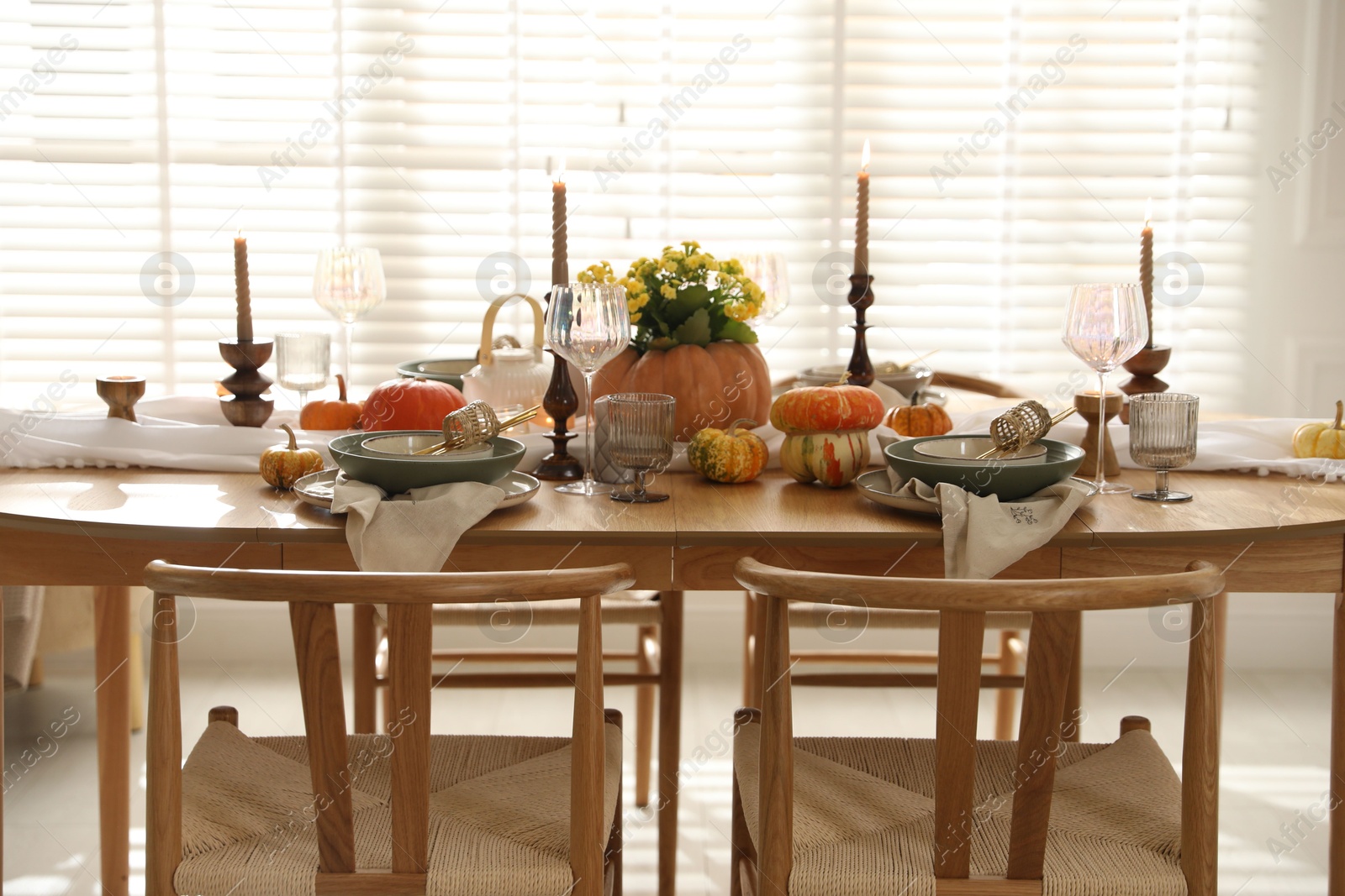 Photo of Stylish table setting with beautiful dishware, glasses and autumn decor in dining room