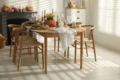 Photo of Stylish dining room with beautiful table setting and autumn decor