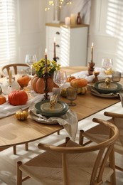 Photo of Stylish table setting with beautiful dishware, glasses and autumn decor in dining room