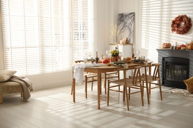 Photo of Stylish dining room with beautiful table setting and autumn decor