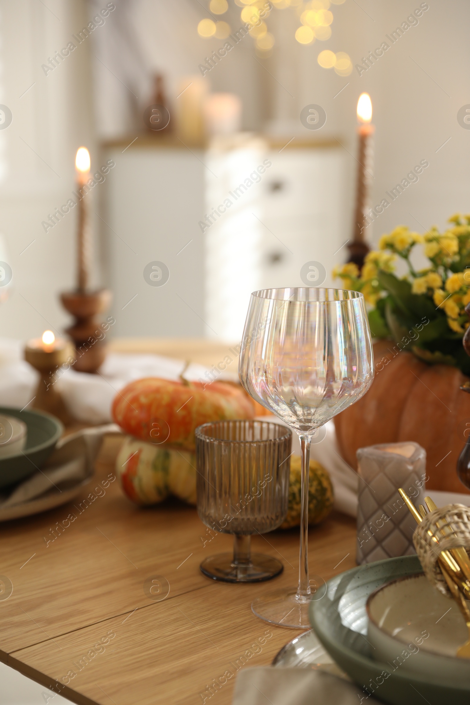 Photo of Stylish table setting with beautiful dishware, glasses and autumn decor in dining room